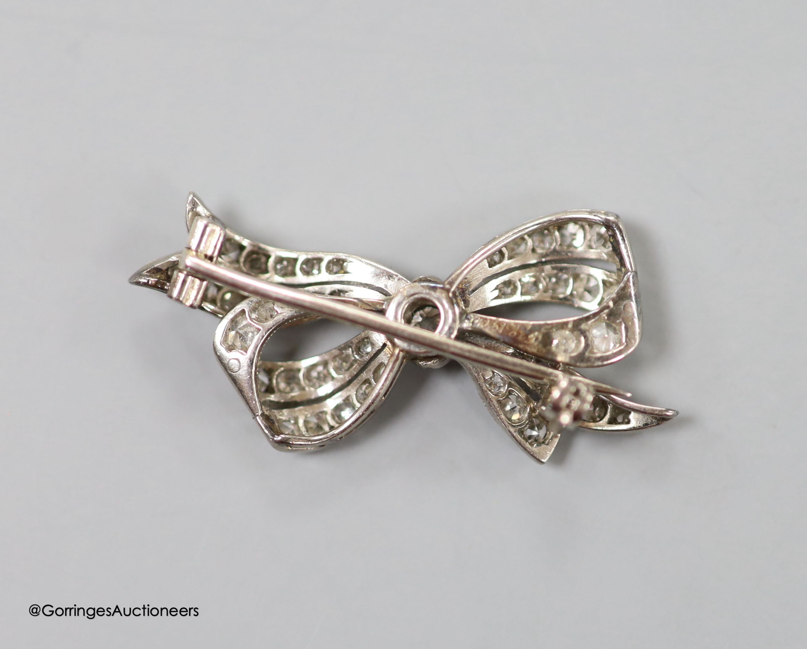 A 1920's/1930's white metal and diamond set bow brooch, 32mm, gross weight 4.5 grams.